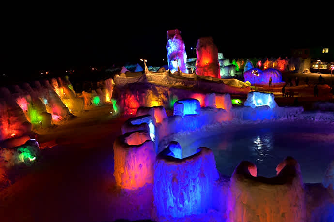 Multicolored lights illuminate the sculptures at night.