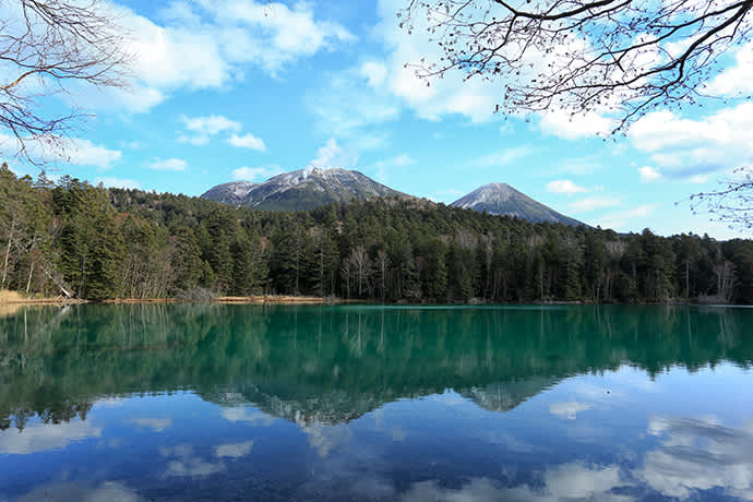 Plumes of volcanic stream rise from Mt. Meakan. Lake Onneto is in the foreground.