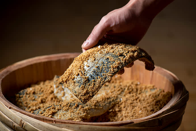 Fish being pickled in rice bran.