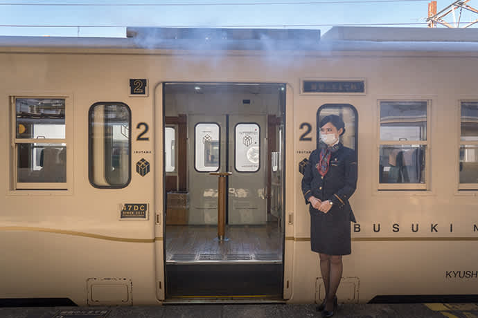 A cloud of vapor billows out from above the train doors.