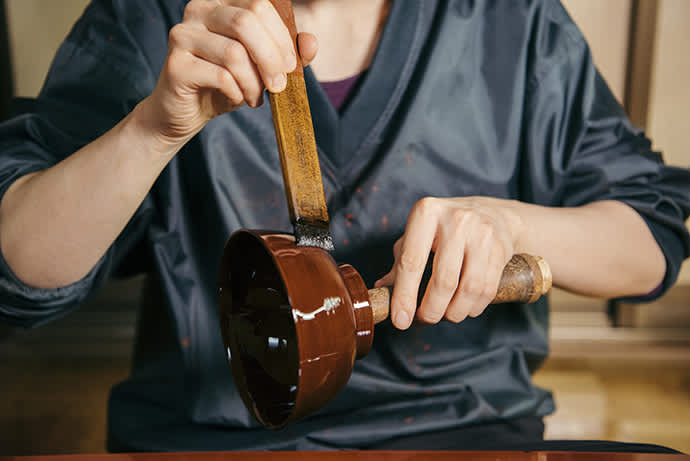 Applying the topcoat. Very few studios use precious Joboji lacquer for all coats.