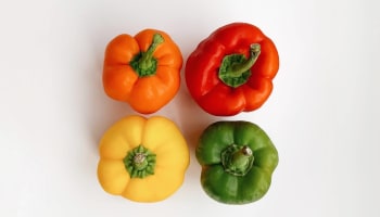 a group of peppers on a white surface