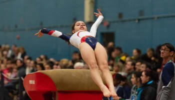 a child jumping on a balance beam