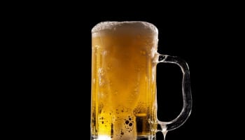 a glass of beer with foam
