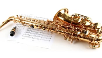 a saxophone lying on a sheet of music