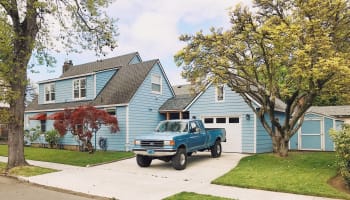a blue truck parked in front of a house