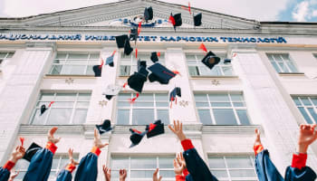 a group of people throwing graduation caps in the air