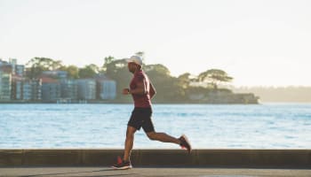 a person running on a road near water