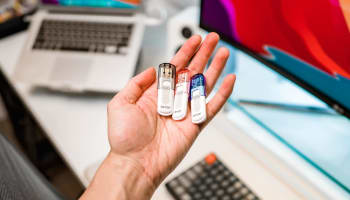 a hand holding several USB drives