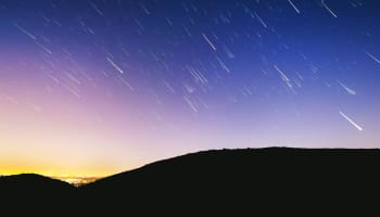 a starry sky over a hill