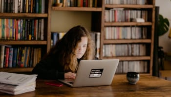 a child sitting at a table with a laptop