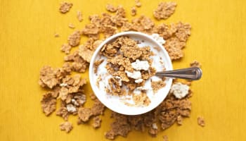 a bowl of cereal with milk and spoon