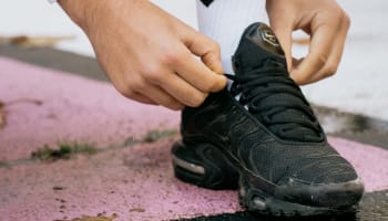 a person's hand on a black shoe