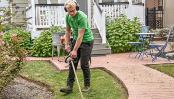 a person wearing headphones and holding a lawn mower