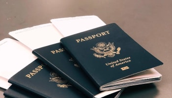 a stack of passports with a few papers