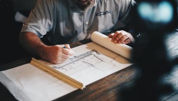a person drawing a blueprint