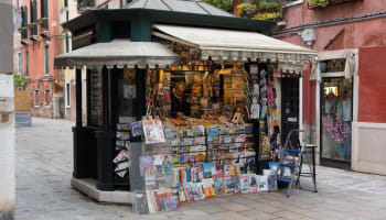 a small kiosk with a person selling newspapers