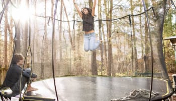 a child jumping on a trampoline