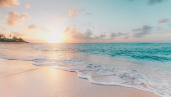 a beach with waves and a sunset