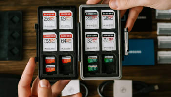 a hand holding a storage box with memory cards