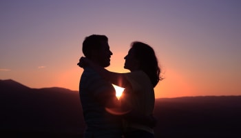 people hugging at sunset