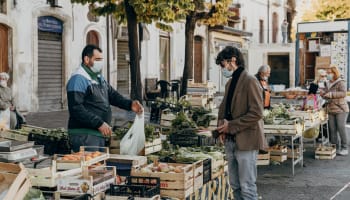 a person buying vegetables at a stall