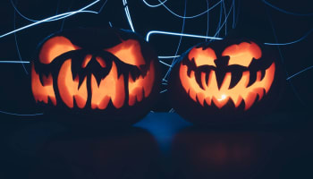a couple of carved pumpkins with glowing faces