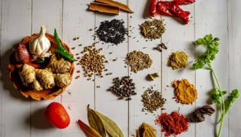 a group of spices and herbs on a white table