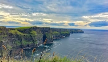 a cliff with grass and water