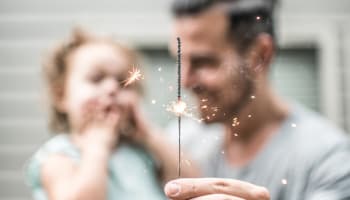 a person and child with sparklers