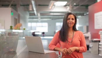 a person sitting at a table with a laptop