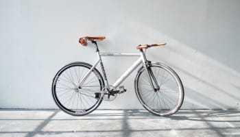 a white bicycle leaning against a white wall