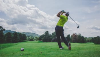 a person swinging a golf club