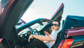 a person sitting in a red car with the doors open