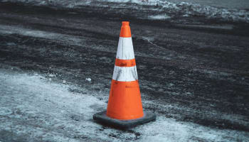 an orange and white cone on a road