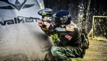 a person in a paintball gear holding a paintball gun