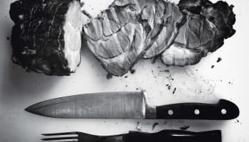 a knife and fork next to meat