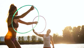 a person holding a hula hoop and standing next to a person