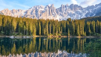 a lake with trees and mountains in the background