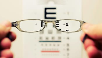 a pair of glasses over a eye chart