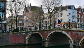 a bridge over a river with buildings in the background