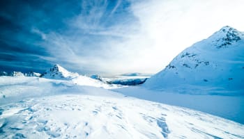 a snowy mountain with a blue sky