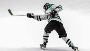 a hockey player in a uniform with a hockey stick
