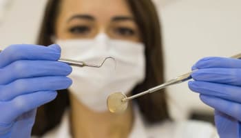 a person holding a dental tool
