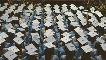 a group of graduates in blue caps