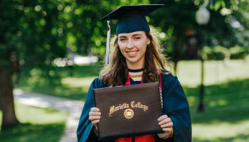 a person in a cap and gown holding a diploma