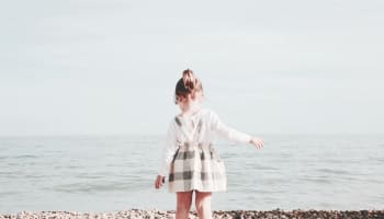 a child standing on a rocky beach