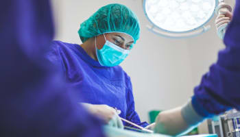 a person wearing surgical scrubs and a mask