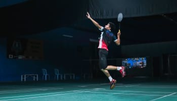 a person jumping in the air with a tennis racket