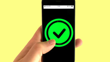 a hand holding a cell phone with a green check mark